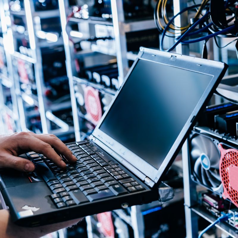 Person Using Laptop In Front Of Wires And Electrical Things