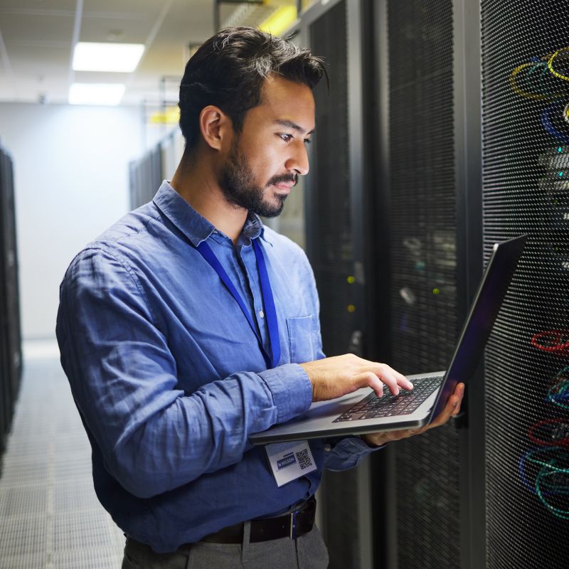 Man Working On Laptop In Front Of Board